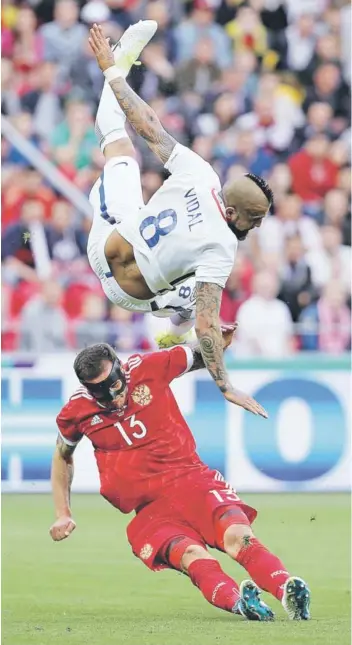  ?? FOTO: CARLOS PARRA/ANFP ?? ►► Vidal cae espectacul­armente en un duelo con Kudryashov.