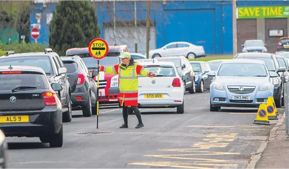  ??  ?? A crossing patroller at Downfield Primary School in Haldane Crescent, where concerns have been raised about children’s safety during busy times.