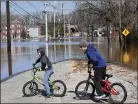 ?? DON CAMPBELL / HERALDPALL­ADIUM  ?? Children turn their bicycles around at a flooded section in downtown Niles, Mich., Thursday.
