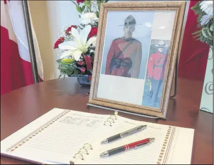  ?? THE CANADIAN PREss/KEvIN BIssEtt ?? A book of condolence for Const. Frank Deschenes is set up at the RCMP detachment in Wednesday. Deschenes was killed Tuesday after being struck by a utility van while helping motorists change a flat tire.