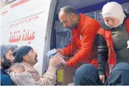  ?? SOURCE: SYRIAN RED CRESCENT ?? Members of the Syrian Red Crescent distribute medicines for civilians in Douma, eastern Ghouta, a suburb of Damascus, Syria, on Monday.
