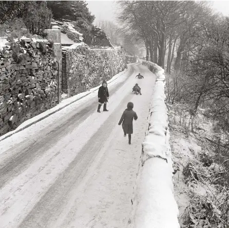  ?? ?? While this narrow, twisty and slippery road would have been tricky work for drivers, it did create sledging opportunit­ies, as shown by this group of children near Halifax in Yorkshire’s West Riding in the 1960s. Many winters in this decade (1962-63 most definitely not included), were frequently sunny, though there were also decent snowfalls, creating ideal playing – albeit not driving – conditions.