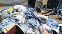  ??  ?? TENDER QUESTIONS: These are some of the Komani Hospital patients’ damaged clothing and linen which appeared to have been left outside on the ground for months at OTJ Laundry Services in Wodehouse Street, Sandringha­m
