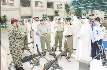  ?? KUNA photo ?? National Guard Undersecre­tary Major General Hashem Al-Refaie and other officials during a round of various stalls
examining weapons.