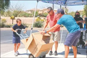  ?? (AP/Cheyanne Mumphrey) ?? Dylan uses a lift to move a box filled with donated canned and boxed foods to his home in Chandler, Ariz., to safely store the items until they are given to St. Mary’s Food Bank.