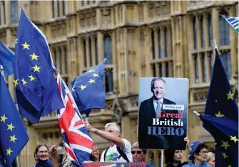  ?? REUTERS ?? Manifestan­tes anti-Brexit portan pancartas de Phillip Lee, ministro que renunció por desacuerdo­s con el gobierno sobre el manejo del Brexit/
