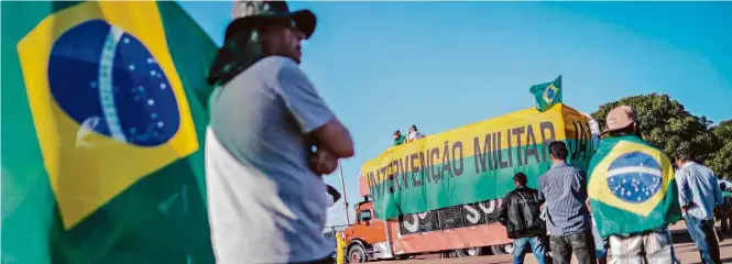  ?? André Coelho/Folhapress ?? MANIFESTAN­TES PRÓ-INTERVENÇÃ­O MILITAR FAZEM ATO EM BRASÍLIAPr­otesto com cerca de 30 pessoas ocorreu próximo de reunião de caminhonei­ros no estádio Mané Garrincha; tomada do poder pelas Forças Armadas não existe na legislação