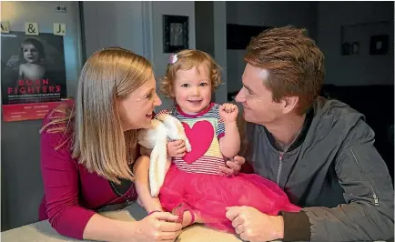  ?? PHOTO: JOSEPH JOHNSON/FAIRFAX NZ ?? Poppy Taggart, 2, with parents Jo, left, and Ashley, is a ‘‘regional hero’’ for Heart Kids. She has 11 heart conditions.