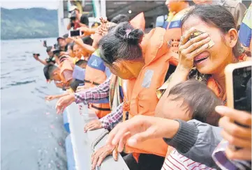  ?? — Reuters photo ?? Relatives of missing passengers react during a visit to the location of the ferry that sank at Lake Toba.