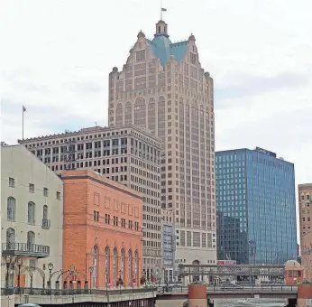  ?? MIKE DE SISTI / MILWAUKEE JOURNAL SENTINEL ?? The 100 East office tower, center, is to be converted into 350 apartments within 40 months.