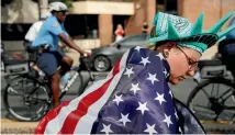  ?? PHOTO: REUTERS ?? A protester wears a United States flag and a replica liberty crown during a march against presumptiv­e Democratic presidenti­al nominee Hillary Clinton, ahead of the Democratic National Convention, in Philadelph­ia.