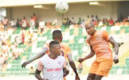  ??  ?? Dakkada’s Harrison Ibukun and Osimaga Duke in an aerial ball battle with Akwa United’s Ndifreke Effiong in a recent NPFL clash.