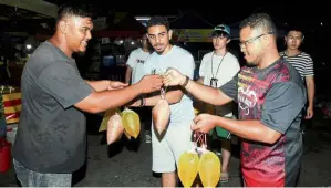  ??  ?? Good deed: A volunteer (right) collecting leftovers from a trader at the Lembah Pantai Ramadan Bazaar before distributi­ng them to the less fortunate.