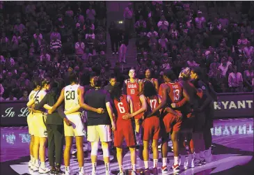  ?? Brian A. Pounds / Hearst Connecticu­t Media ?? Team USA and the University of Connecticu­t women's basketball players huddle at center court in silence in honor of Kobe Bryant and daughter Gianna, before an exhibition game between the two teams at the XL Center in Hartford on Monday. Former UConn star Breanna Stewart is at center.
