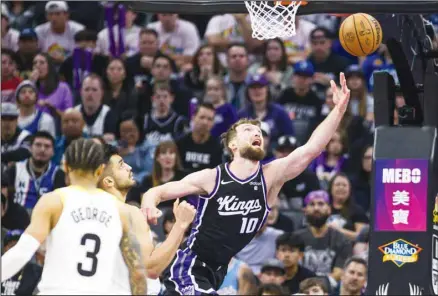  ?? ?? Sacramento Kings forward Domantas Sabonis (10) lays the ball up over Utah Jazz guard Keyonte George (3) and center Omer Yurtseven during the second half of an NBA basketball game in Sacramento, Calif., Sunday, March 31, 2024. The Kings won 127-106. (AP)