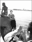  ??  ?? Tourists pose for photos at the Little Mermaid statue at the Langelinie Quay in Copenhagen.