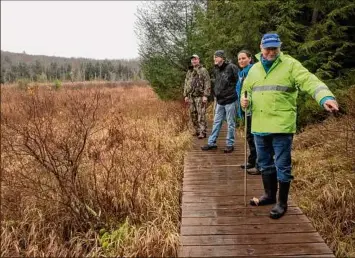  ?? Lori Van Buren / Times Union archive ?? Forest steward Fred Mccagg, at left, stands with the Rensselaer Plateau Alliance’s executive director Jim Bonesteel, communicat­ions director Annie Jacobs and board member Jeff Briggs on a boardwalk in the Poestenkil­l Community Forest in Sand Lake. The RPA has worked to save wetlands to protect areas from flooding as a step to combat climate change.