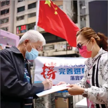  ?? EDMOND TANG / CHINA DAILY ?? A Hong Kong resident signs a petition on March 14 in support of Chinese top legislatur­e’s decision to improve HK’s electoral system. More than 2.38 million people voiced their approval by March 21.