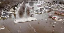  ?? DAVE KETTERING / TELEGRAPH HERALD ?? The swollen Pecatonica River spills into downtown Darlington, Wis., on Thursday. Wisconsin Gov. Tony Evers said the “bomb cyclone” had “moved across the entire state” between Wednesday and Friday. In its wake, he said, water was “rising swiftly.”