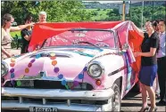  ?? LIU BIN / XINHUA ?? Beijing tourism officials unveil a vintage car at an event on Sept 9 to promote the city to Cuban visitors.