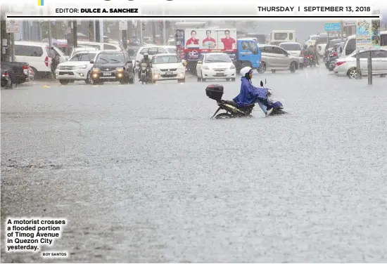  ?? BOY SANTOS ?? A motorist crosses a flooded portion of Timog Avenue in Quezon City yesterday.