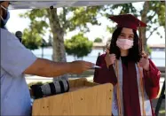  ?? RECORDER PHOTO BY NAYIRAH DOSU ?? A Granite Hills High School graduate gives a thumbs up after having her name called, Wednesday, May 27, 2020, at the Grizzlies drive-thru graduation.