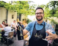  ?? FOTO: ANNE ORTHEN ?? Griechenla­nd mitten in Düsseldorf: Bei Askitiz serviert Deniz Durmus im Garten kühlen Weißwein.