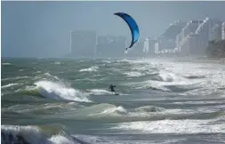  ?? JOE CAVARETTA/SOUTH FLORIDA SUN-SENTINEL VIA AP ?? A kite surfer enjoys the wind Monday in Lauderdale, Fla.