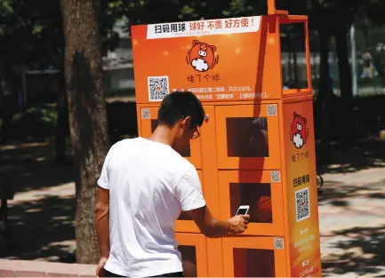  ?? (Thomas Peter/Reuters) ?? A MAN USES a courtside basketball vending machine at Beijing Language and Culture University last week. China’s government expects the ‘sharing economy’ to grow about 40% this year to 4.83 trillion yuan ($705 billion). By 2020, it should account for...