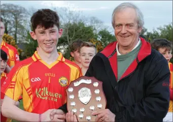  ??  ?? John O’Neill presents the shield to Conal Kervick, the Davidstown-Courtnacud­dy captain.