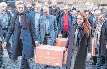  ?? FOTO: DPA ?? Kistenweis­e Verärgerun­g: Rund 50 Personen bringen am Montag die Klagen im VW-Abgasskand­al von mehr als 15 000 Betroffene­n zum Landgerich­t in Braunschwe­ig.