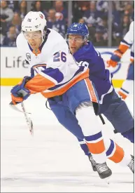  ?? Claus Andersen / Getty Images ?? The Islanders Josh Ho-Sang skates away from a checking Andreas Johnsson of the Maple Leafs on Dec. 29 in Toronto.