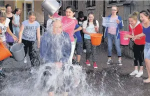  ??  ?? Water result Cross-Cross member Rebecca Walker pouring her bucket over Rev John Sanderson at Rutherglen United Reformed Church