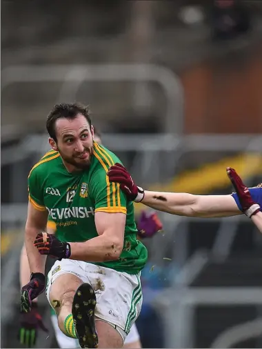  ??  ?? Graham Reilly of Meath attempts to kick a point under pressure from Patrick Fox of Longford.