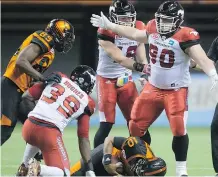  ?? DARRYL DYCK/ THE CANADIAN PRESS ?? Calgary Stampeders' defence has set the tone this year — such as on this play last week, when Quinn Smith, right, sacked B.C. Lions' quarterbac­k Jonathon Jennings.