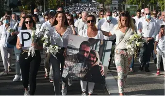  ??  ?? Lors de la marche blanche organisée dans la cité basque, le 8 juillet 2020 (en tête de cortège, Véronique Monguillot portant une photo de son mari).