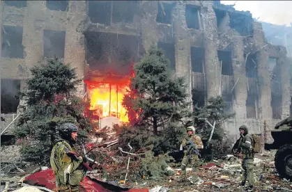  ?? REUTERS ?? Service members of pro-Russian troops stand in front of the destroyed administra­tion building of Azovstal Iron and Steel Works in Mariupol, Ukraine.