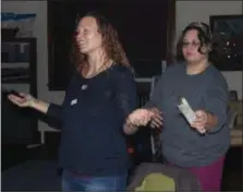  ??  ?? Nikole Ackley, owner of the Spirit Holistic Center in Boyertown, uses a burning sage stick to cleanse the space and a participan­t of a New Moon Ritual, Stephanie Dubeck, of Barto.