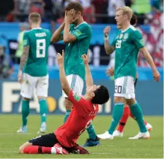  ??  ?? ECSTASY AND AGONY: Germany’s players walk off the pitch dejected as South Korea’s Ju Se-jong, front, celebrates.