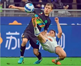  ?? AFP ?? Inter Milan’s Italian midfielder Nicolo Barella (left) and Empoli’s Albanian midfielder Kristjan Asllani go for the ball during their Italian league football match at the San Siro stadium in Milan on Friday. Milan won 4-2. —