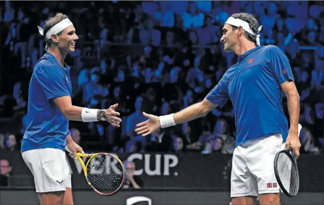  ?? ?? Rafa Nadal y Roger Federer, rivales durante muchos años y compañeros ayer, chocan la mano tras lograr un punto en el último partido de la carrera del suizo.