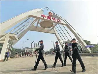  ?? PHOTOS PROVIDED TO CHINA DAILY ?? Left: Policemen of the Hekou immigratio­n inspection station patrol the border port in Hekou county, Yunnan province. Right: Guo Rui with a Vietnamese visitor in Hekou.