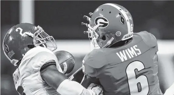  ?? STAFF PHOTOS BY C.B. SCHMELTER ?? Alabama defensive back Tony Brown intercepts a pass intended for Georgia wide receiver Javon Wims during the College Football Playoff national championsh­ip game at Mercedes-Benz Stadium on Monday in Atlanta.