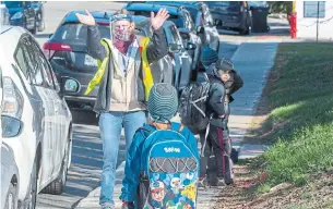  ?? RYAN REMIORZ THE CANADIAN PRESS ?? Teacher Janick Mille welcomes students at École Marie Rose in St-Sauveur, Que., as elementary schools outside the greater Montreal area reopen Monday.