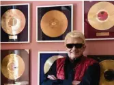  ??  ?? Stolz auf über 50 Millionen Platten: Heino posiert zu Hause vor seiner „Goldenen Wand“.