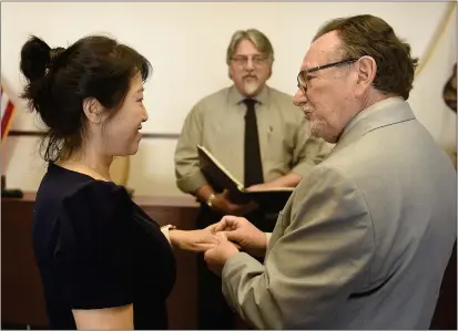  ?? PHOTOS BY JOEL ROSENBAUM — THE REPORTER ?? Yanping Li (left) and Michael Damgaard of Vallejo exchange their wedding vows during a civil marriage ceremony last week at the Solano County Government Center. The couple met during the early days of the Coronaviru­s pandemic and wanted their ceremony to coincide with the Lunar New Year celebratio­n in Asian cultures and Valentine's Day.