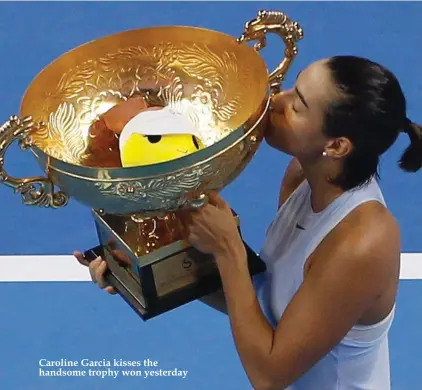  ??  ?? Caroline Garcia kisses the handsome trophy won yesterday