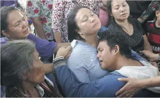  ?? BINSAR BAKKARA/THE ASSOCIATED PRESS ?? Family members of a victim of a military plane crash comfort each other Tuesday at a hospital in Medan, Indonesia. The 141 dead include 122 people on board plus residents of Medan.