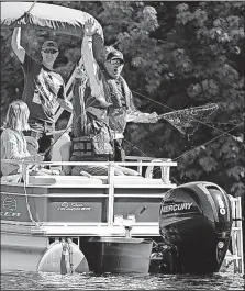  ?? STAR TRIBUNE] [SHARI L. GROSS/MINNEAPOLI­S ?? Minnesota Gov. Mark Dayton reels in a 17.5-inch smallmouth bass, held up in a net by fishing guide Todd Bissett, that he caught last month in St. Cloud, Minn.