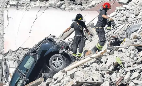  ?? Picture: PA. ?? Rescuers make their way through destroyed houses in Pescara Del Tronto.